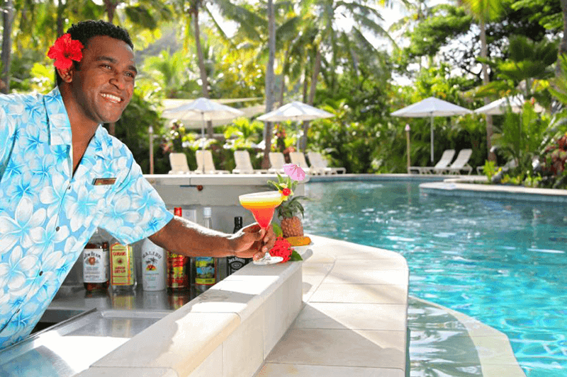 Castaway Island Fijian server with cocktail at pool bar - 