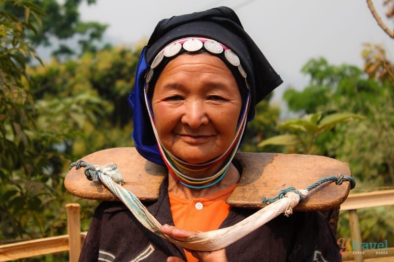 Akha hill tribe woman carrying wooden board across neck