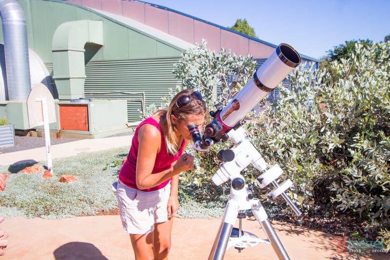 woman looking through a telescope