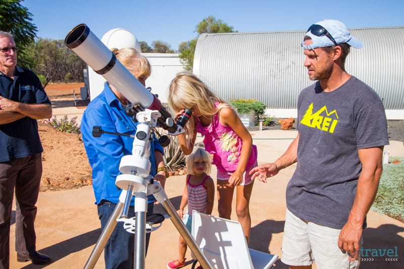 girl looking through a telescope