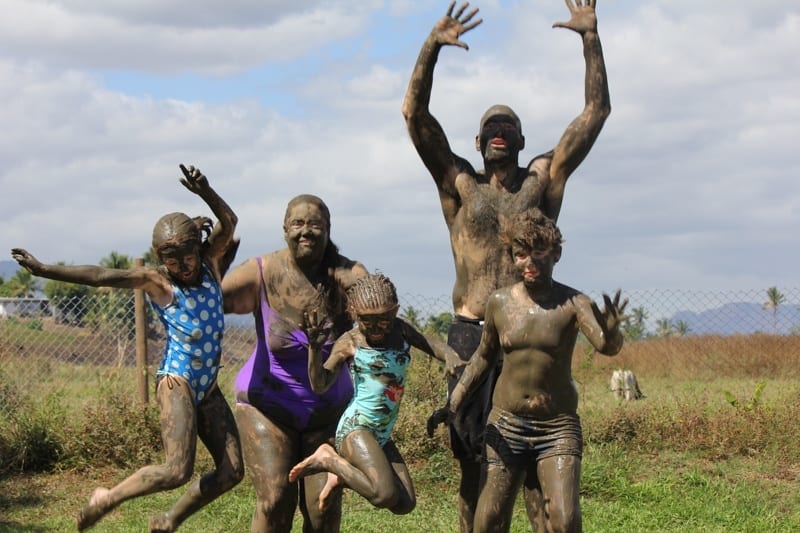 family caked in mud jumping