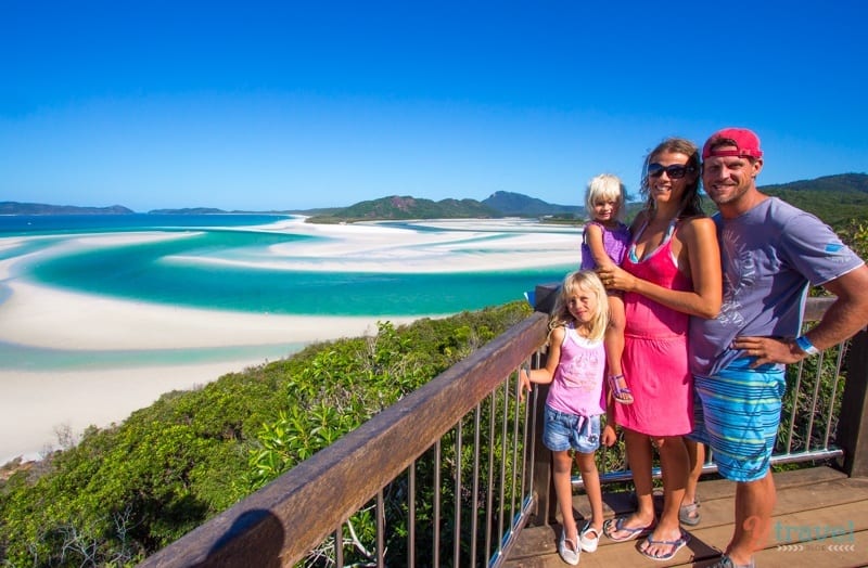 family posing in front of Whitehaven Beach, Queensland, Australia