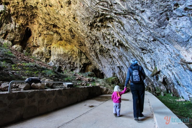 woman and child walking through the entrance to Yarrangobilly Caves,