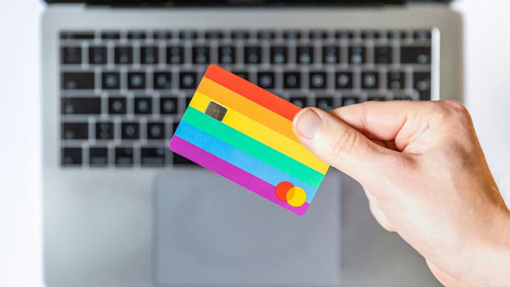 person holding credit card near computer