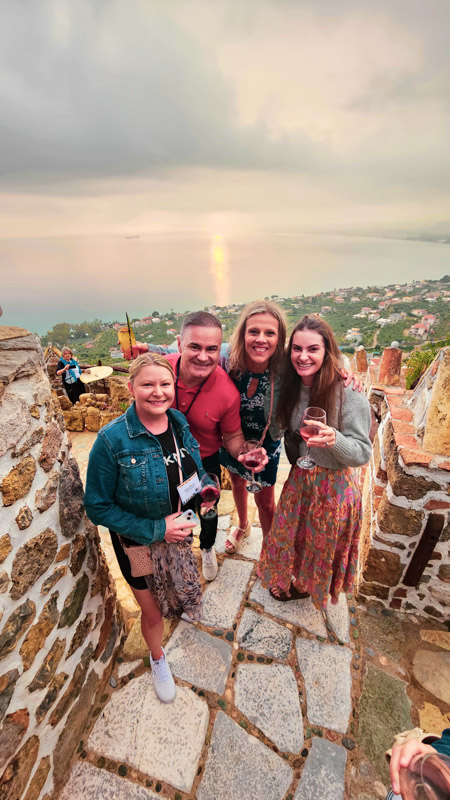 caz with blogging friends cheersing with sunset behind them