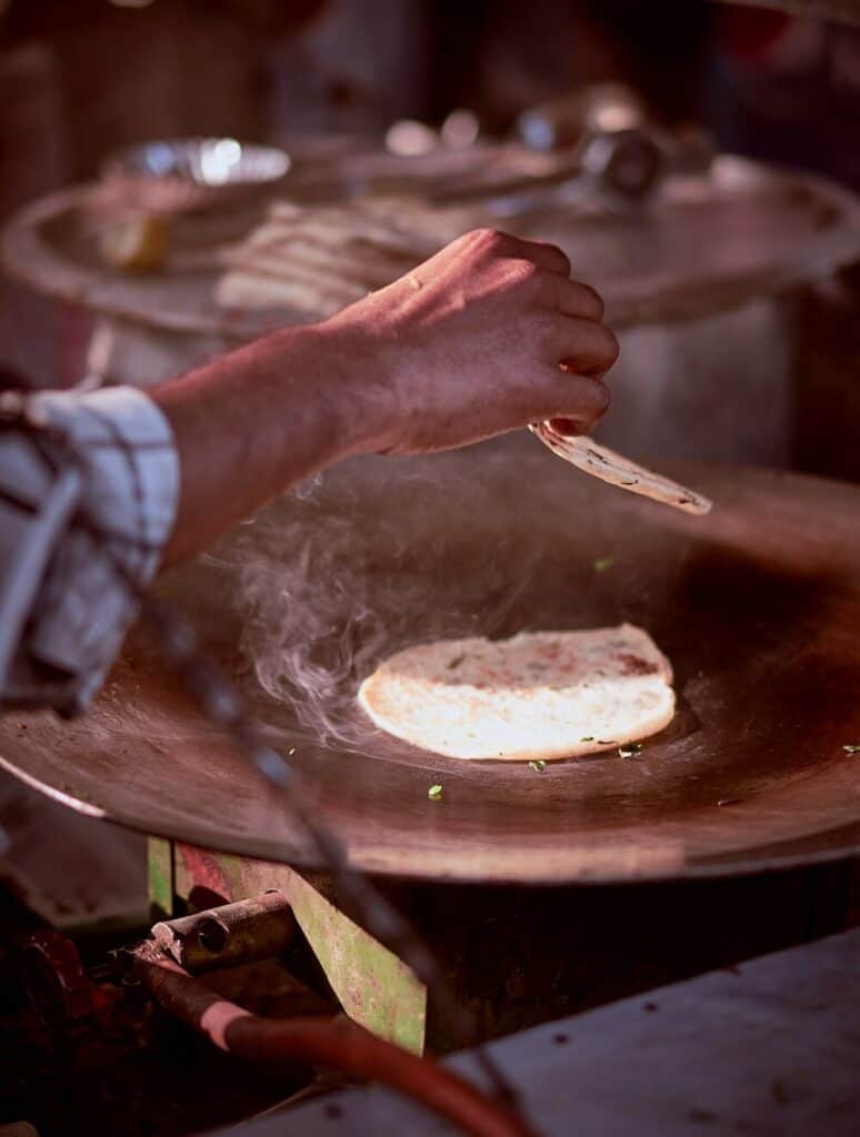 person cooking street food in india