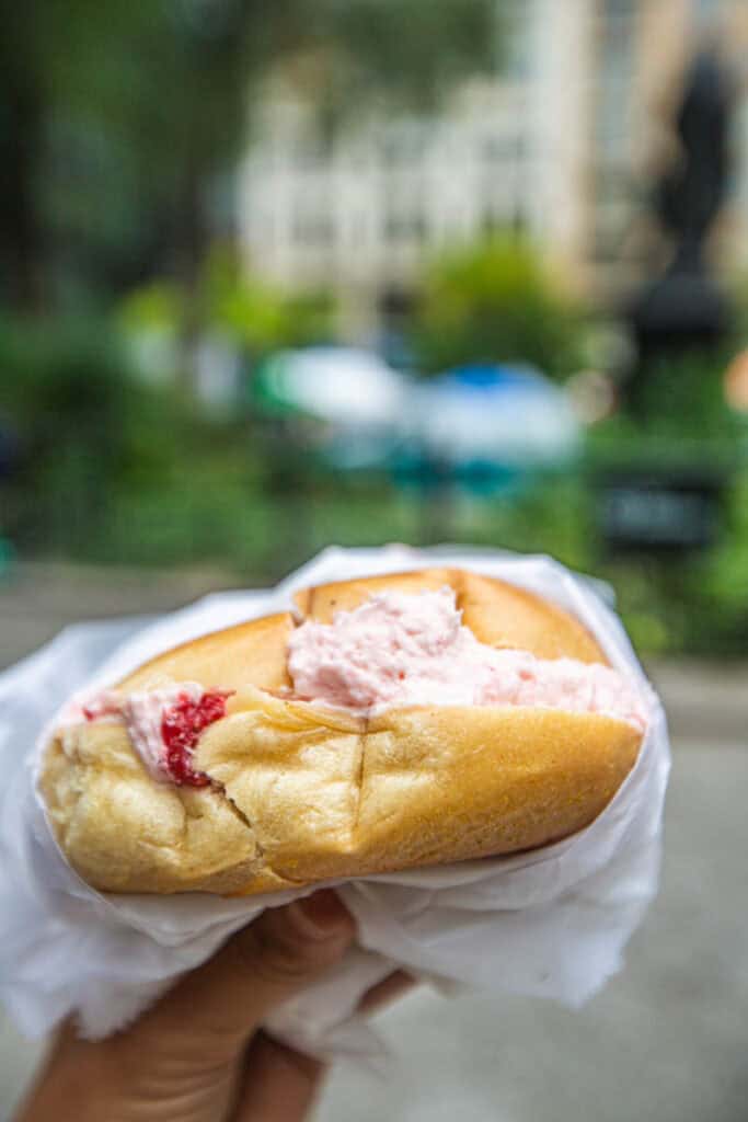 person holding strawberry cream cheese bagel