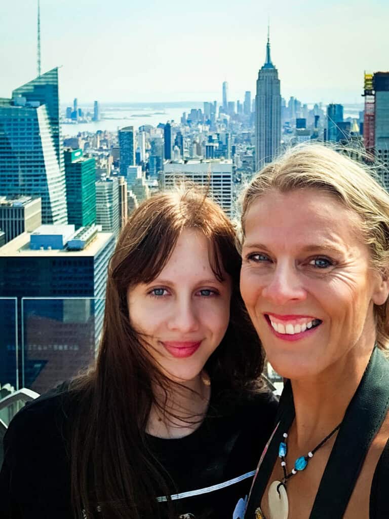 mother and daughter selfie on top of the rock with empire state building behind