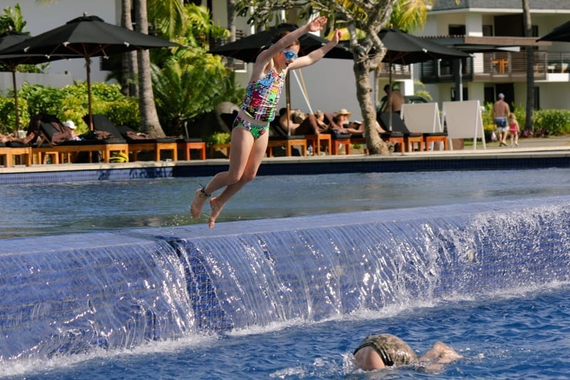 girl jumping into pool