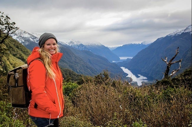 girl posing in front of Milford Sound, 