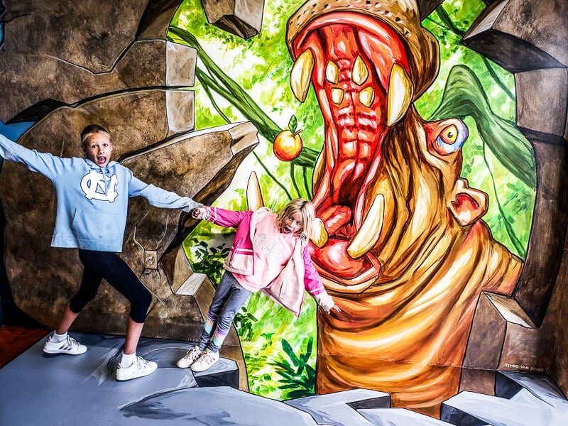 girl taking selfies with art work at selfie museum