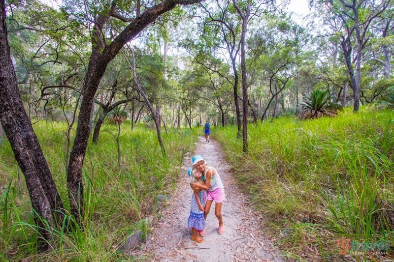 girls hugging on a forest trail