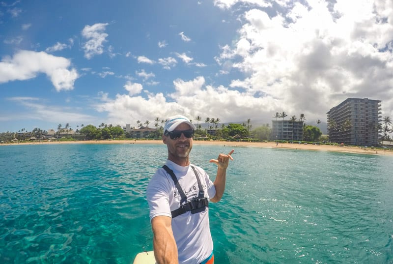 man taking a selfie while Stand up paddle boarding at Kaanapali Beach in Maui, Hawaii