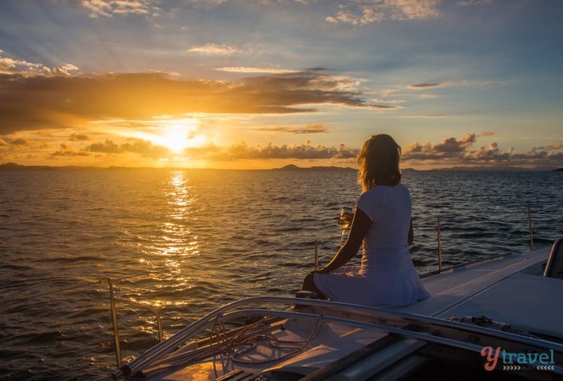 woman on catamaran watching sun set