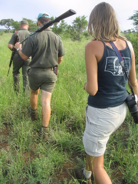 woman on walking safari with guides with guns on shoulders