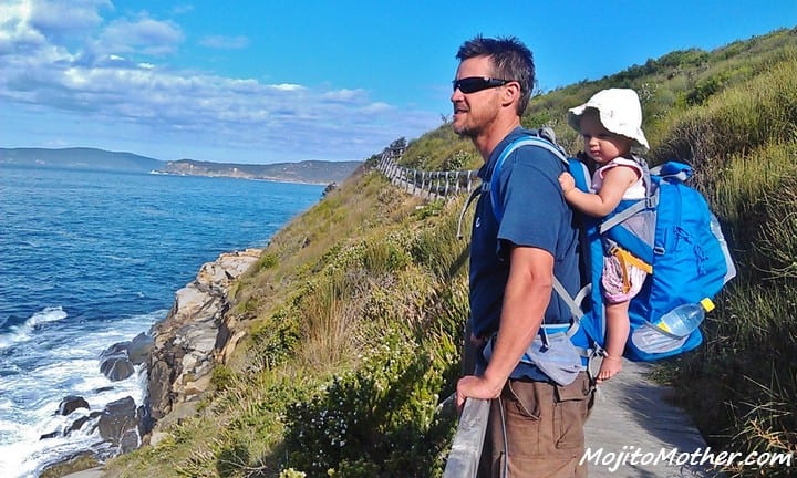 man with baby in Kelty Child Carrier on his back looking at ocean view