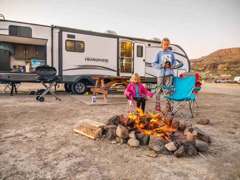 girls around campfire in front of RV at Maverick Ranch RV Park Lajitas Big Bend Texas