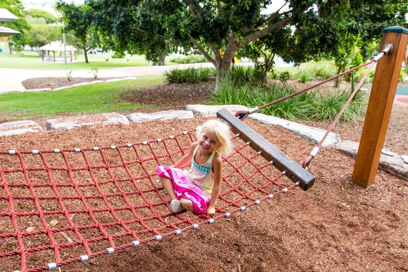 girl on hammock swing at Queens Park Playground 