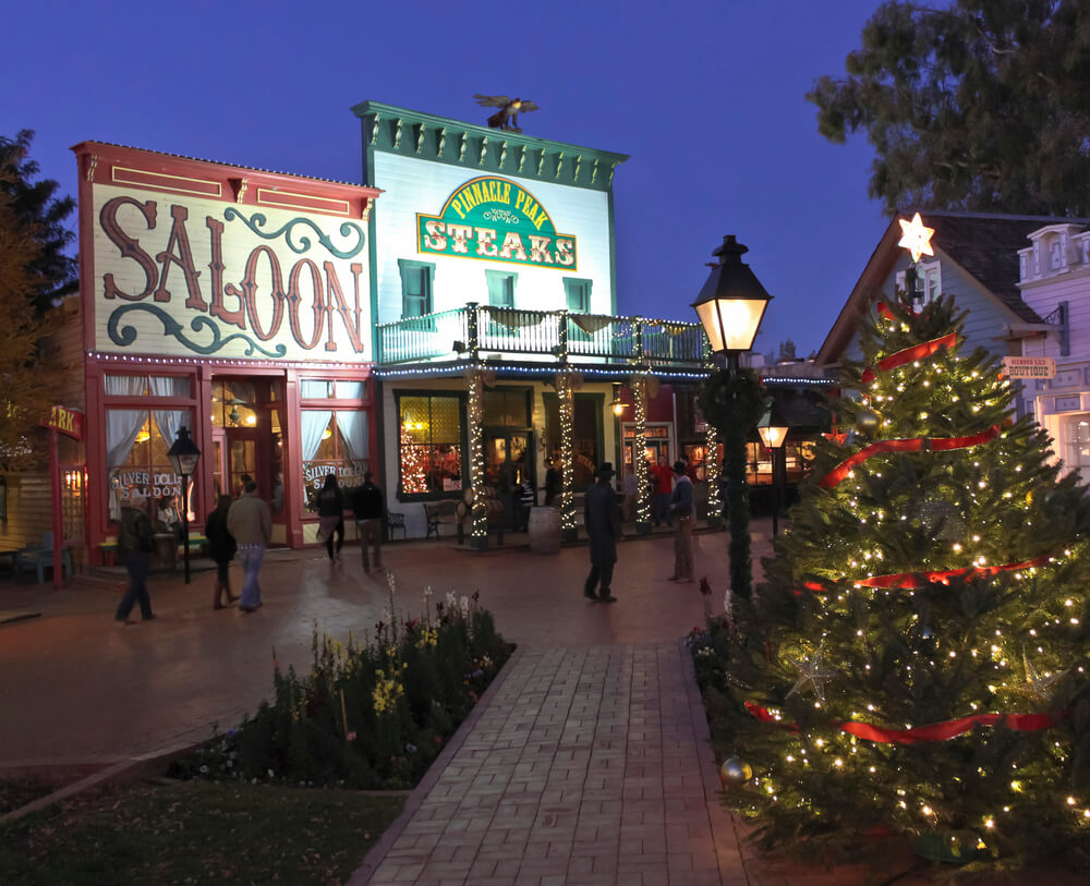 people walking through an outside mall decorated for christmas