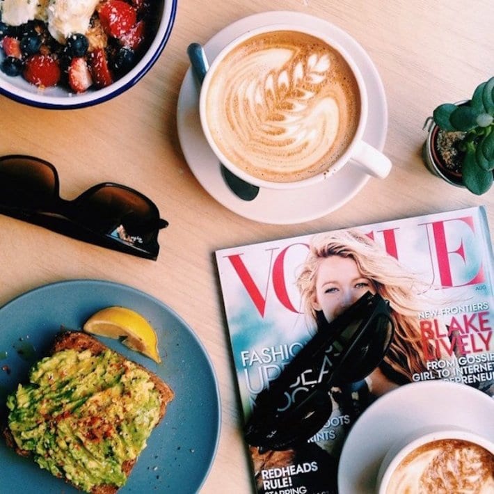 coffee on table with magazine and avocado toast