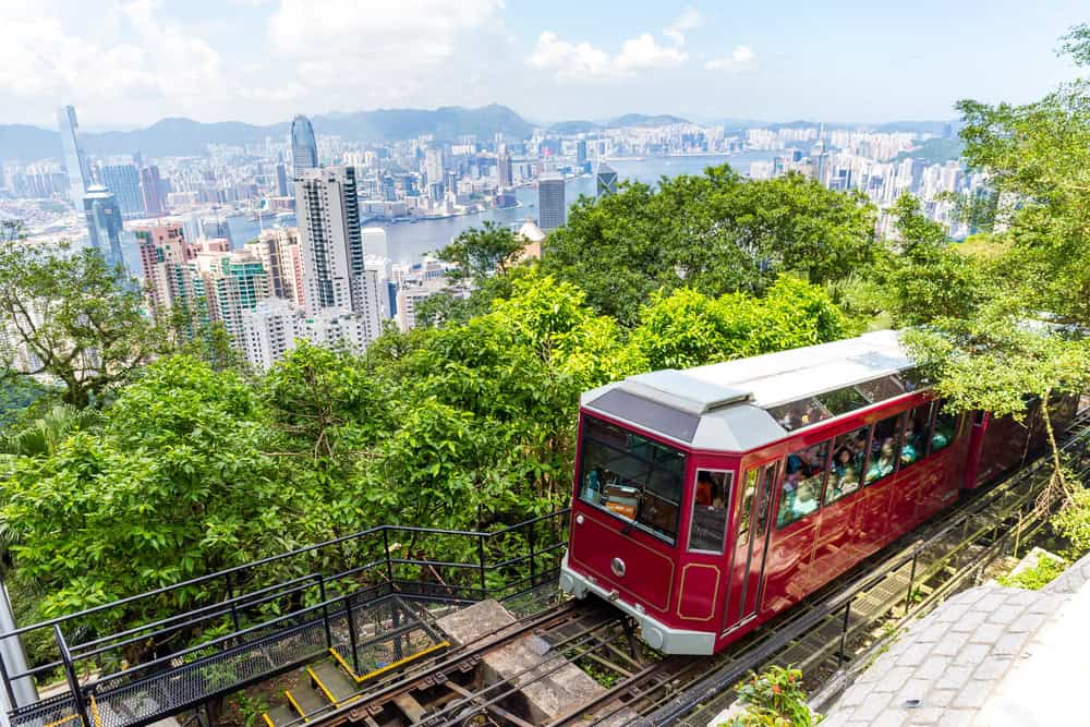 tram going up to victoria peak with hong kong skyline in background