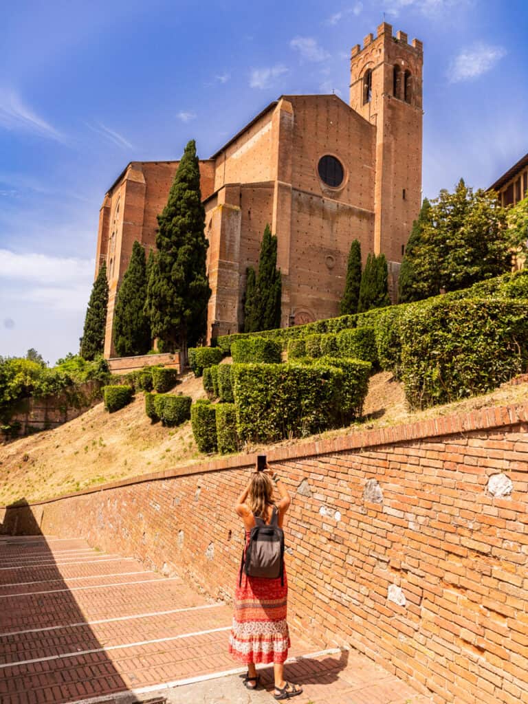 woman taking photo of cathedral in sienna tuscany