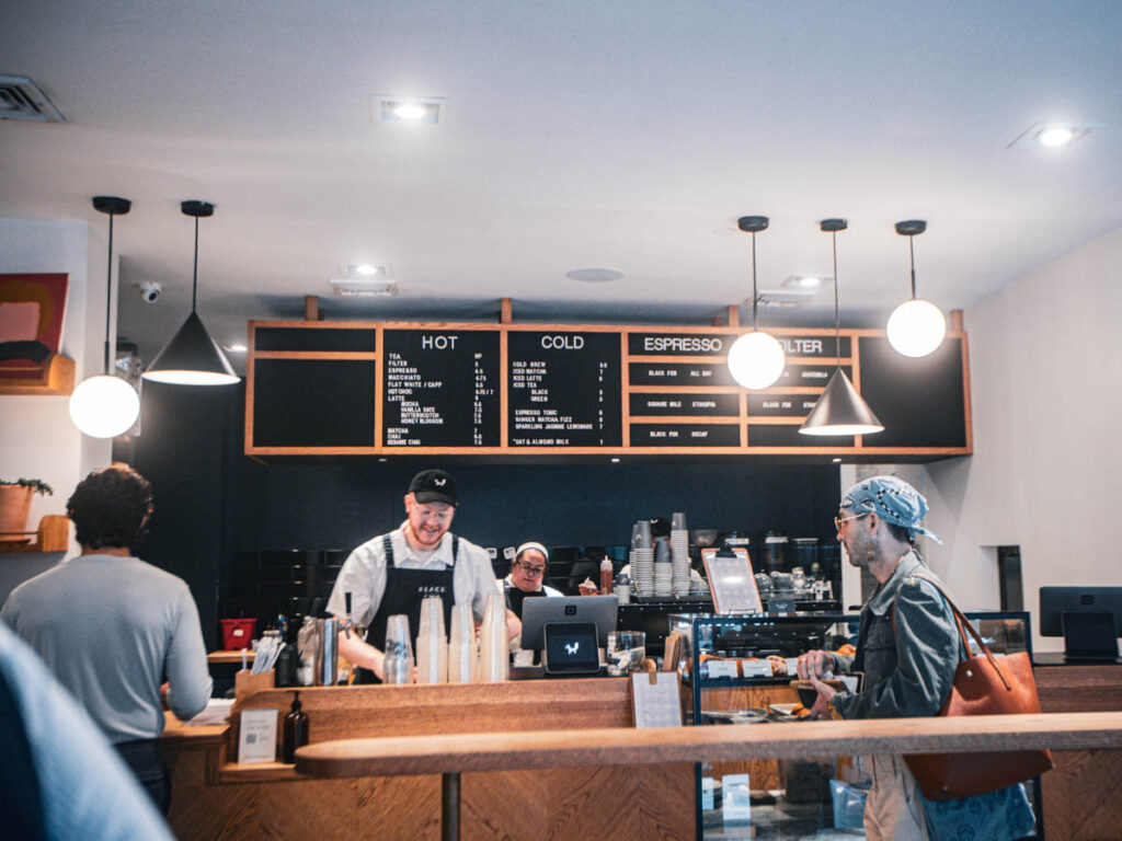 man at black fox coffee counter