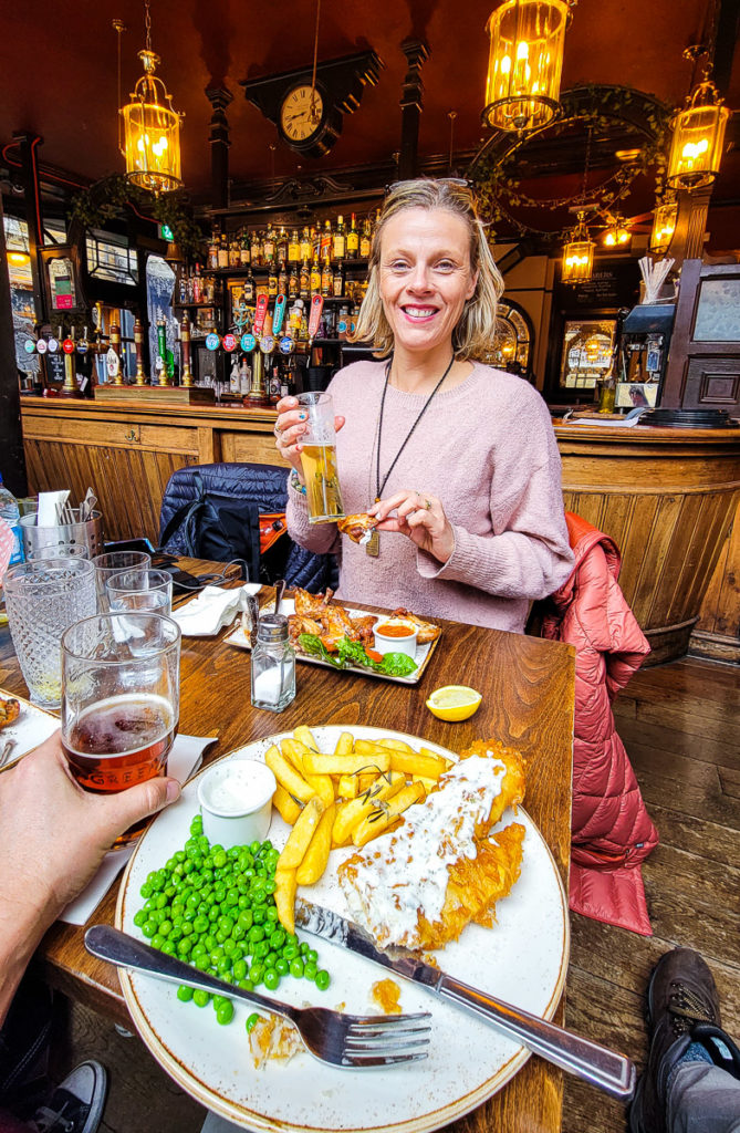 woman eating  fish & chips in a London Pub