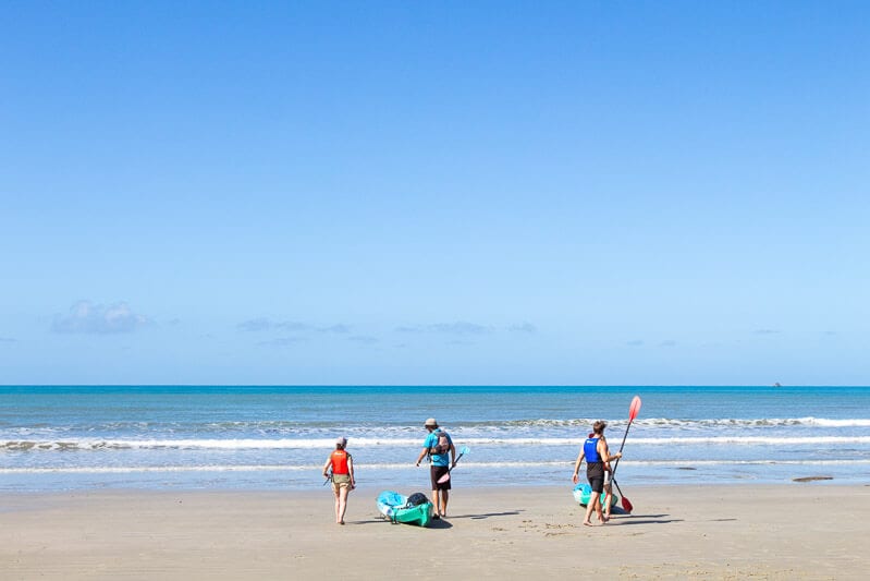 people with kayaks on Cape Tribulation Beach 