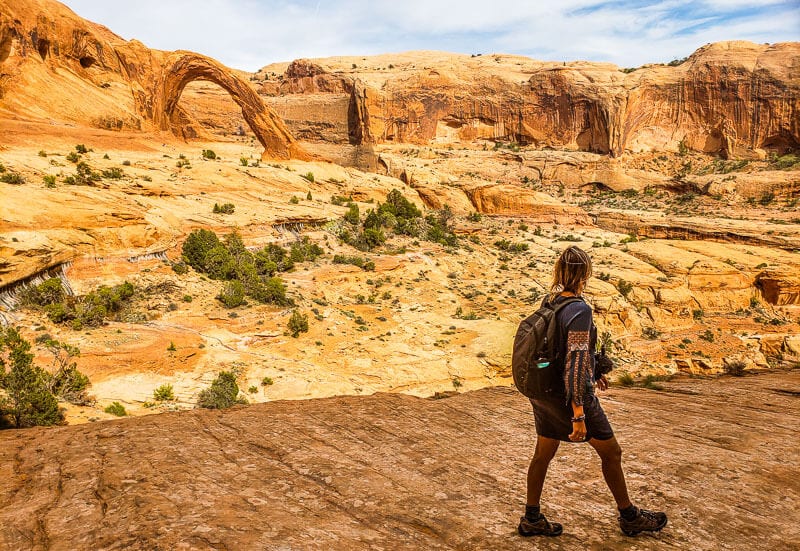 woman hiking near arches in canyon