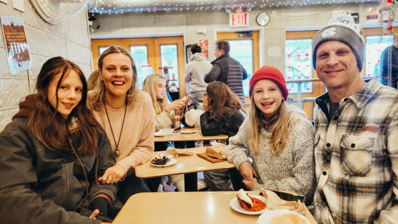 family sitting at table smiling at camera