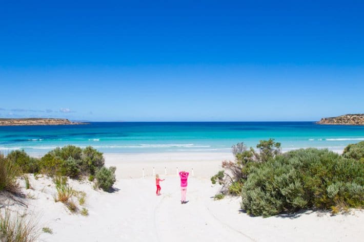 girls walking down a beach