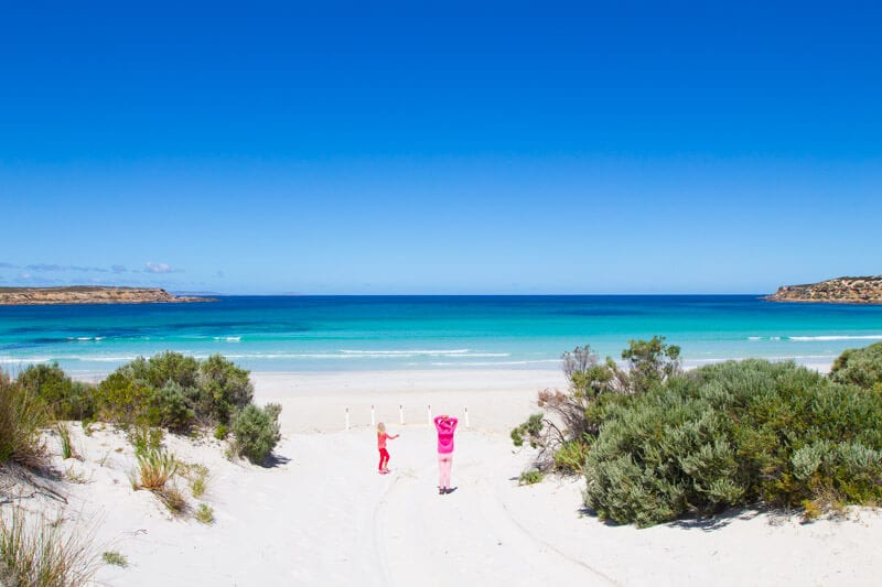 people walking down a beach