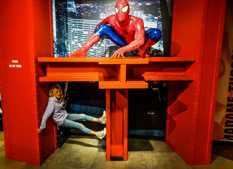 child posing with superman wax figure