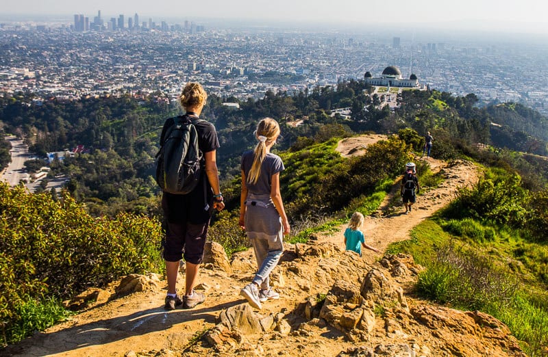 lady and kids hiking along rim Griffith Park with views of LA skyline and observatory