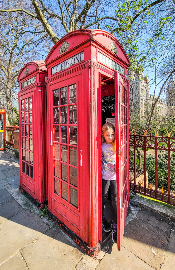 girl inside red phone booth in London, England