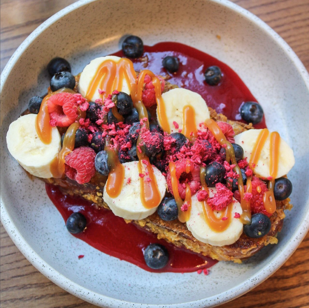 Challah French toast coated in cornflakes and served with banana, berries, freeze dried raspberries, and butterscotch sauce on a berry coulis. 