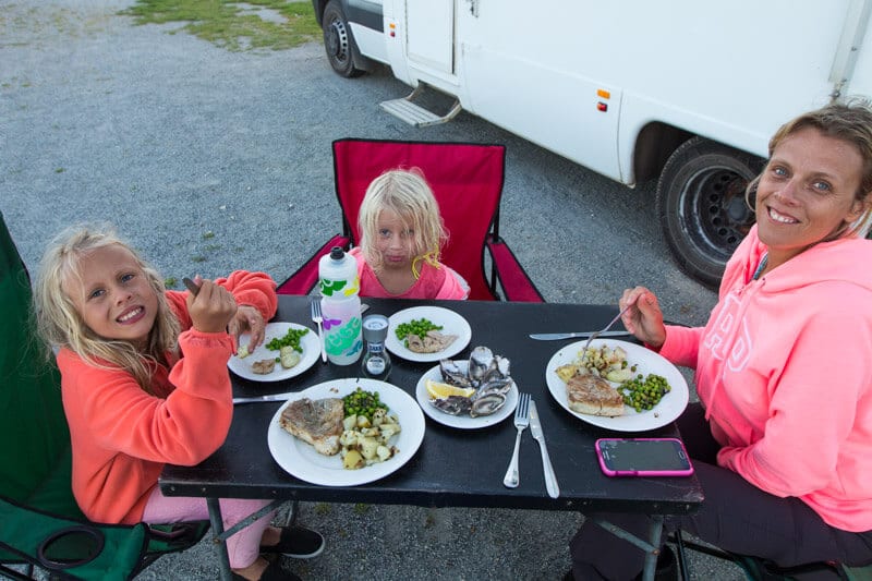 A little girl sitting at a table eating food