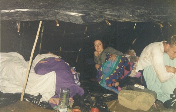 people sleeping under tarp in jungle