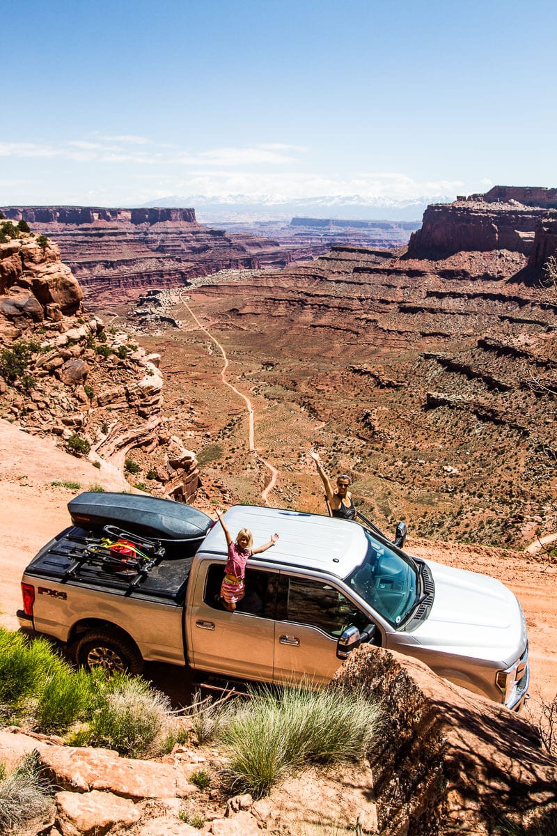 girl hanging out of car posing on Shafer Trail Drive, Canyonlands National Park, Utah