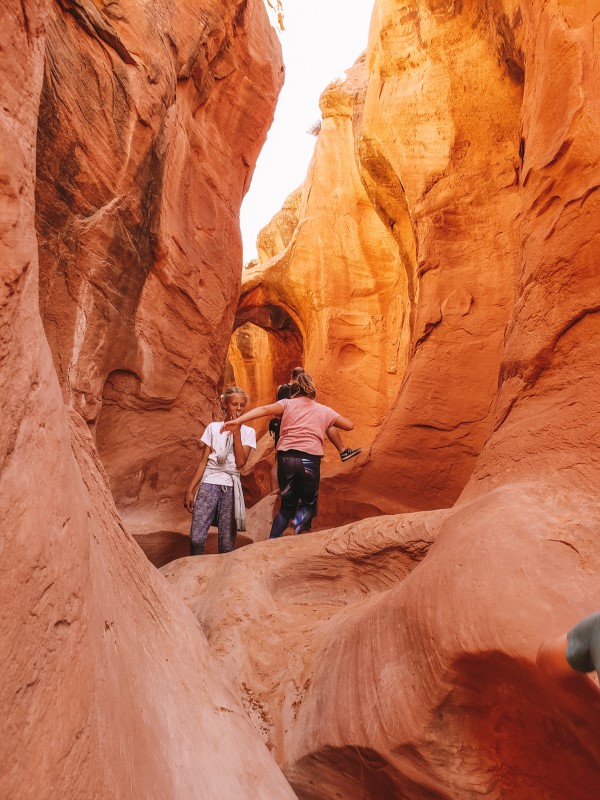 kids walking through Peek a boo slot canyon g