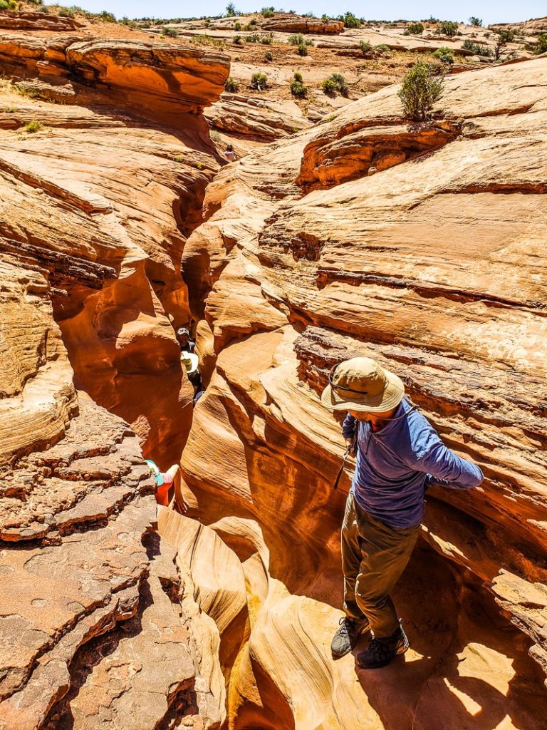 people walking through narrow slot canyon