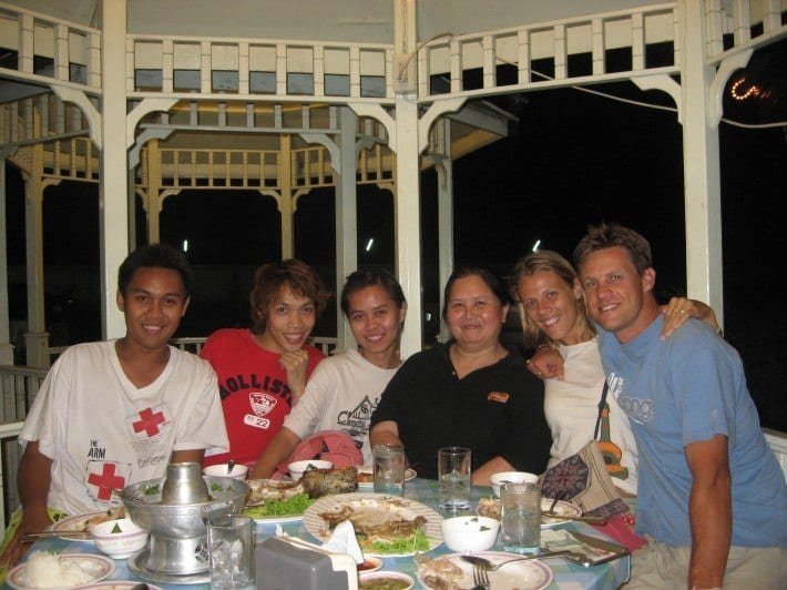 group of english and thai friends eating dinner