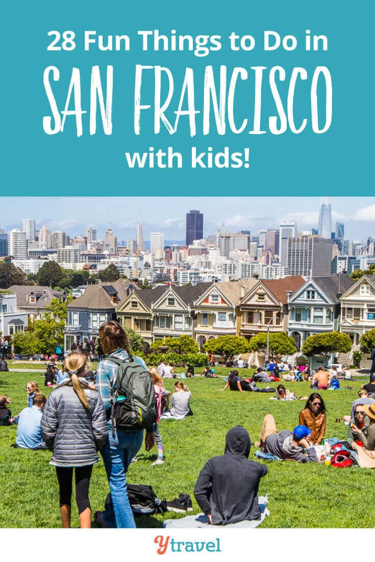 people sitting on grass in front of houses