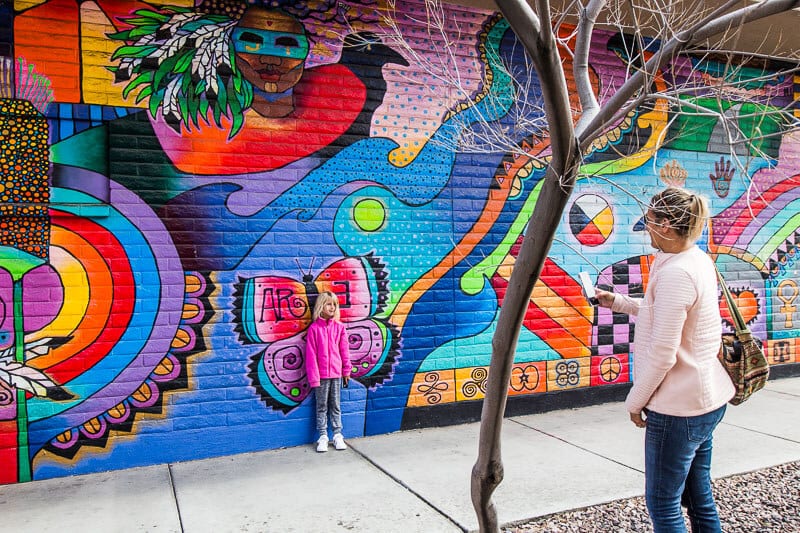 child posing in front of Murals in Downtown Tucson