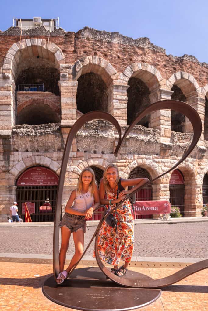 caz and savannah posing inside love heart sculpture in front of VErona arena