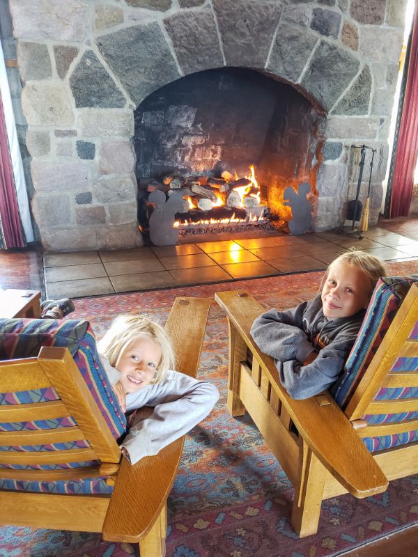 two girls on rocking chairs in front of fire