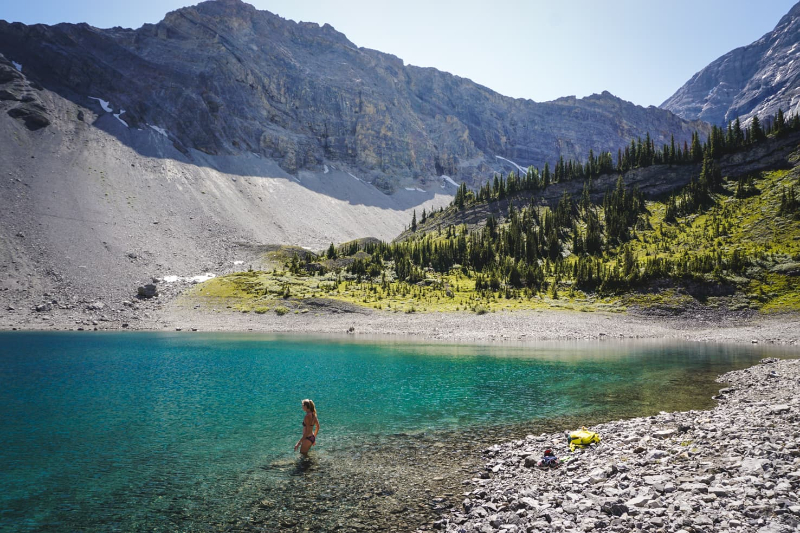 A body of water with a mountain in the background