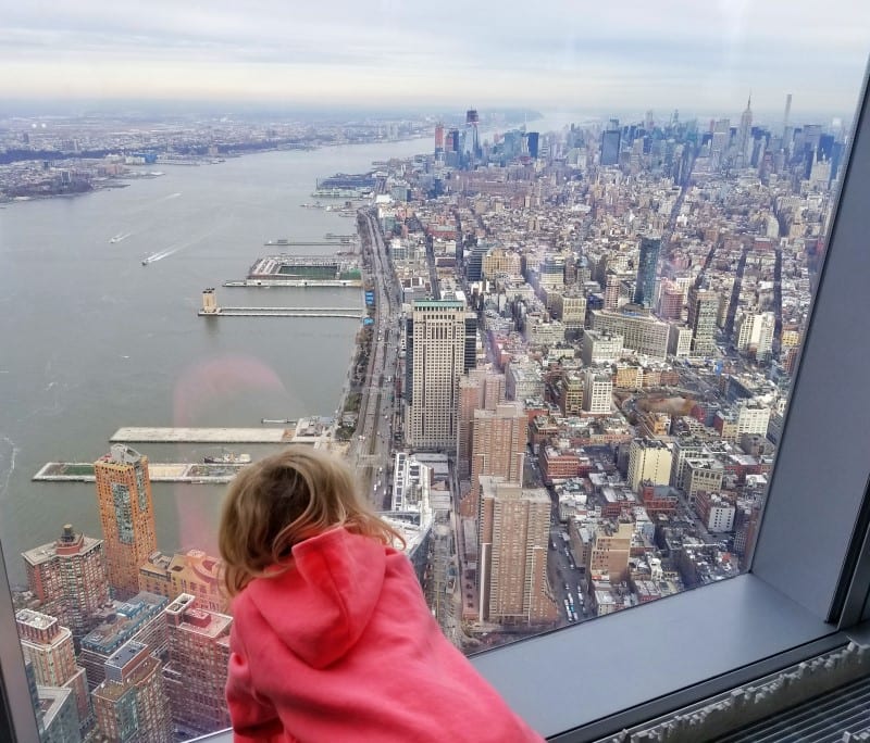 girl looking at One World Observatory views Freedom Tower NYC