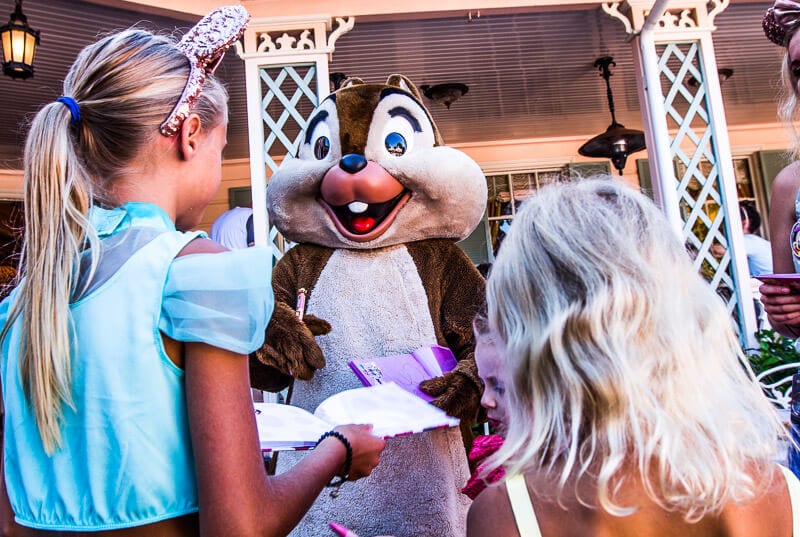 young girls getting disney autograph book signed by chipmunk